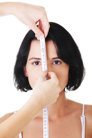 Woman head being measured by female hands の写真素材