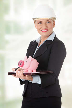 Mature engineer woman with piggybank. の写真素材