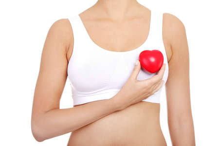 Fit female torso in white sport bra with red heart shaped toyの写真素材