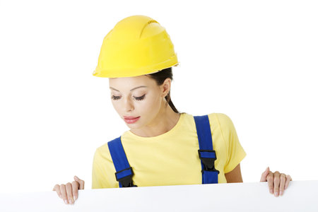 Female construction worker with blank board, isolated on whiteの写真素材