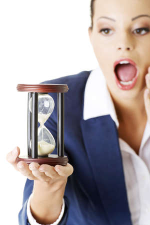 Young shocked business woman with hourglass - time concept の写真素材