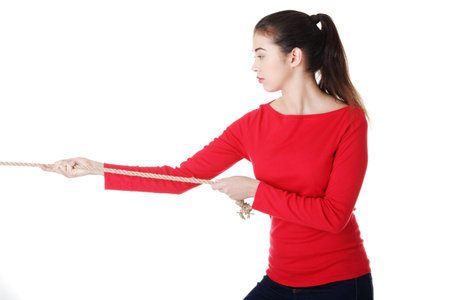Adultl woman pulling a rope, isolated on white 