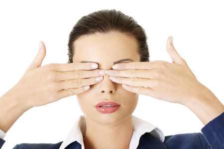 Attractive businesswoman covering her eyes with hands, isolated on whiteの写真素材