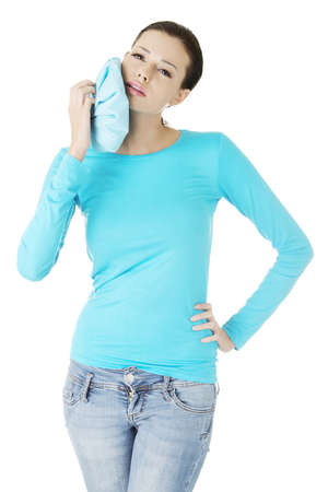 Woman pressing her bruised cheek with a painful expression as if she's having a terrible tooth ache.の写真素材