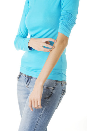 Young woman scratching her self. Isolated on white 