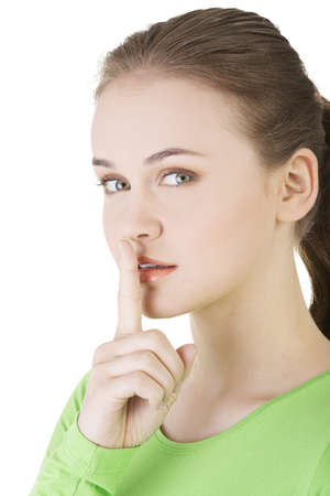 Hush be quiet woman isolated. Teen girl with finger on her lips. の写真素材