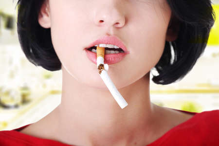 Young woman with broken cigarette. Stop smoking concept.の写真素材