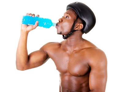 Handsome man drinking , wearing a bicycle helmet.  isolated on white. の写真素材