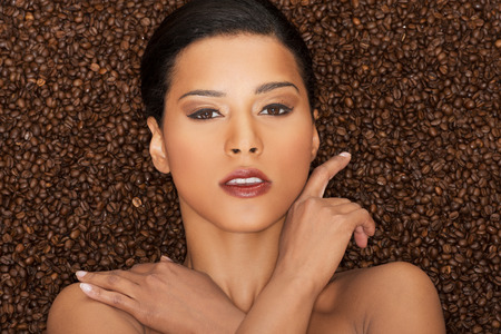 Attractive woman lying in coffee grains. Fron view. Closeup.の写真素材