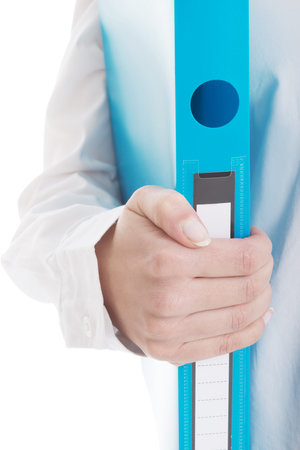 Young business woman holding binder. Focus on blue binder in hand. Over white background.
