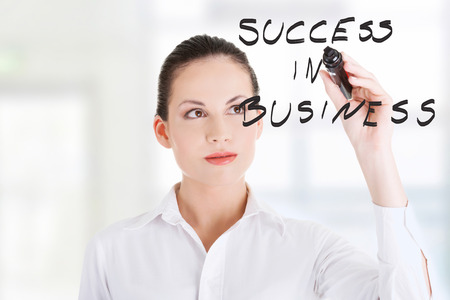 Young businesswoman writing something on abstract screen の写真素材