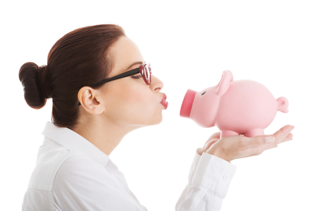 Beautiful business woman holding piggy-bank. Isolated on white.の写真素材