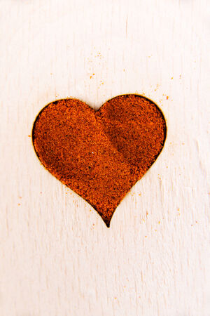 Heart shape made from spice on a wooden spoon. Composition.の写真素材