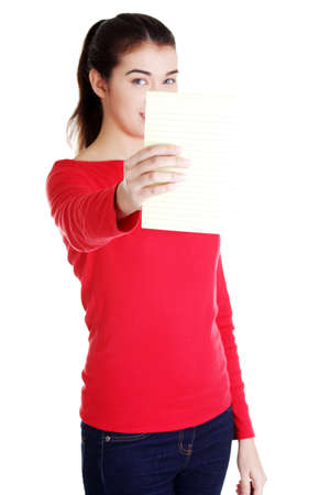 Young happy student woman showing blank notepad, isolated on white background の写真素材
