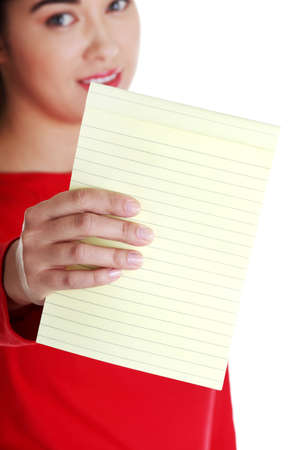 Young happy student woman showing blank notepad, isolated on white background の写真素材