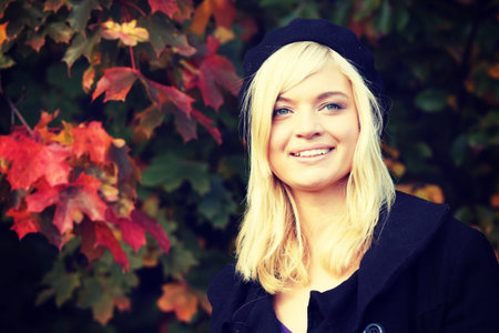 Young caucasian blonde woman portrait with autumn background