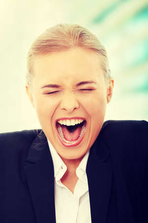 Young business woman shouting loudの写真素材