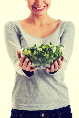Young casual woman eating lamb's lettuceの写真素材