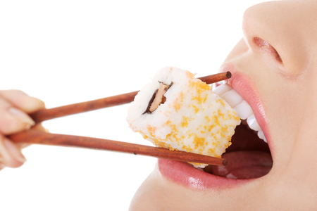 Happy woman eating tasty sushiの写真素材