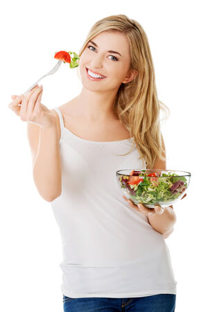 Smiling woman eating healthy salatの写真素材
