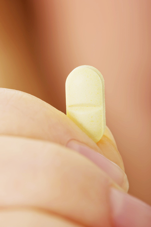 Woman with pill in handの写真素材
