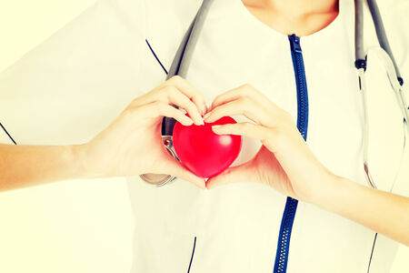 Young nurse with heart in her hand , isolated on white.の写真素材