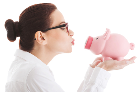 Woman giving a kiss to her piggybank.の写真素材