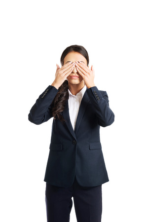 Full length young businesswoman covering eyes with hands.の写真素材