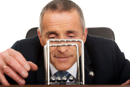 Businessman in office playing with newton balls.の写真素材