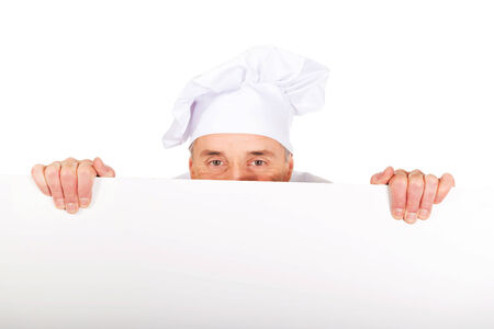 Experienced chef in white uniform holding empty banner.の写真素材