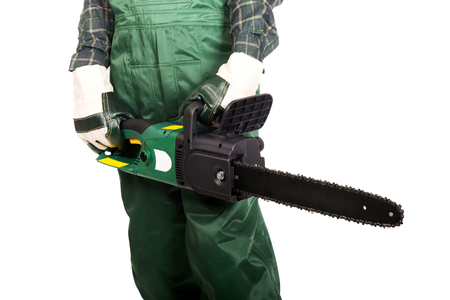 Gardener in green uniform and gloves holding chainsaw.の写真素材