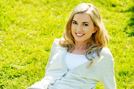 Young smiling woman lying on the grassの写真素材