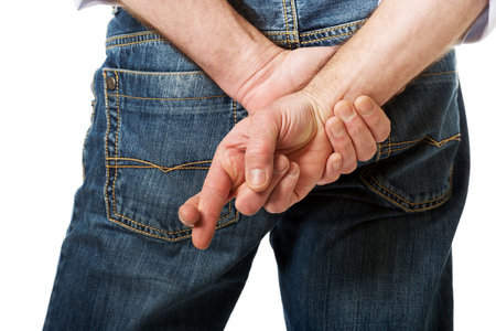Male hands with crossed fingers.