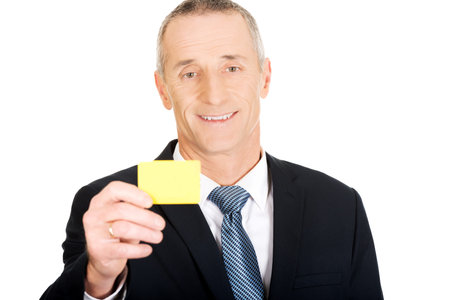 Mature businessman showing a yellow identity name card.の写真素材