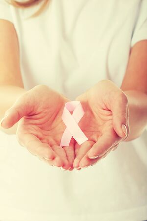 Womans hands holding pink breast cancer awareness ribbonの写真素材