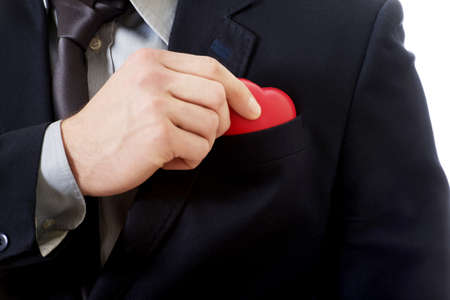 Handsome businessman putting small heart from pocket.の写真素材