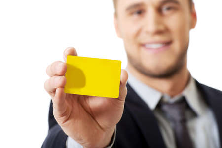 Handsome businessman showing his yellow personal card.の写真素材