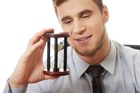 Businessman holding hourglass in the office.