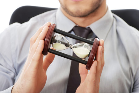 Businessman holding hourglass in the office.