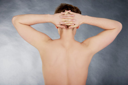 Young shirtless man with hands on head.の写真素材
