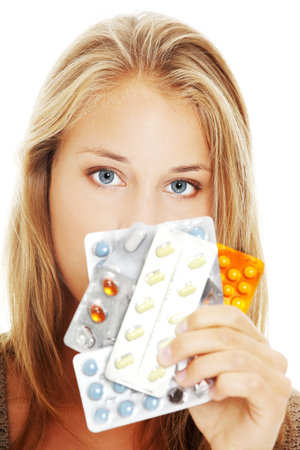 Young beautiful woman holding pillsの写真素材