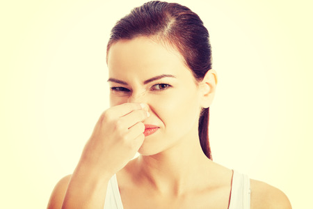 Woman pinches her nose to block a bad smell.の写真素材