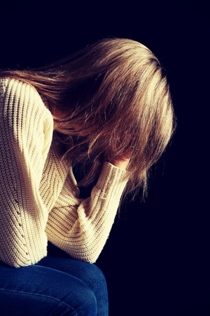 Depressed lonely woman with head in hands.の写真素材