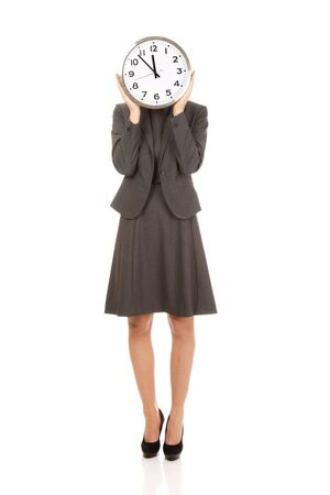 Business woman covering face with clock.の写真素材