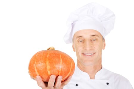Male chef in uniform holding a pumpkinの写真素材