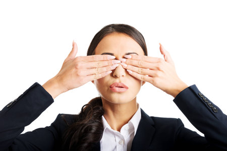 Portrait of young businesswoman covering eyes with hands.の写真素材