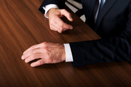 Mature businessmans hands put on the desk.