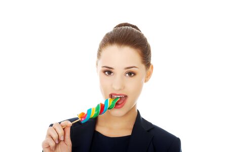 Young happy businesswoman licking a lolipopの写真素材