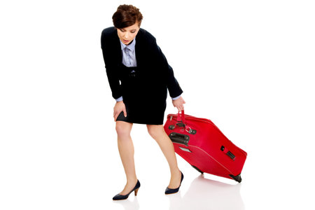 Tired and exhausted businesswoman with suitcase.の写真素材