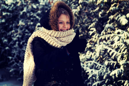 Teenage woman in winter clothes outdoor with thumbs upの写真素材